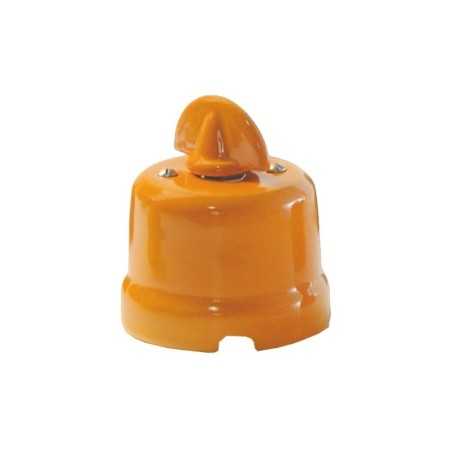 Comutador de porcelana com laço de cor vermelha.