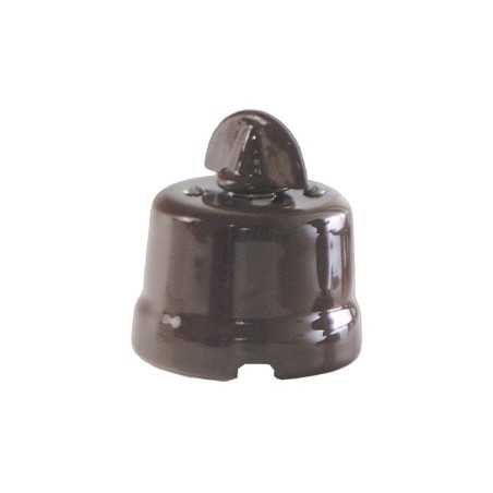 Comutador de porcelana com laço de cor vermelha.